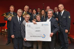 Bonns Leitender Polizeidirektor Helmut Pfau (re) und Christa Wennmann vom Kulturverein übergeben einen Spendenscheck an Polizeipfarrerin Claudia Heinemann