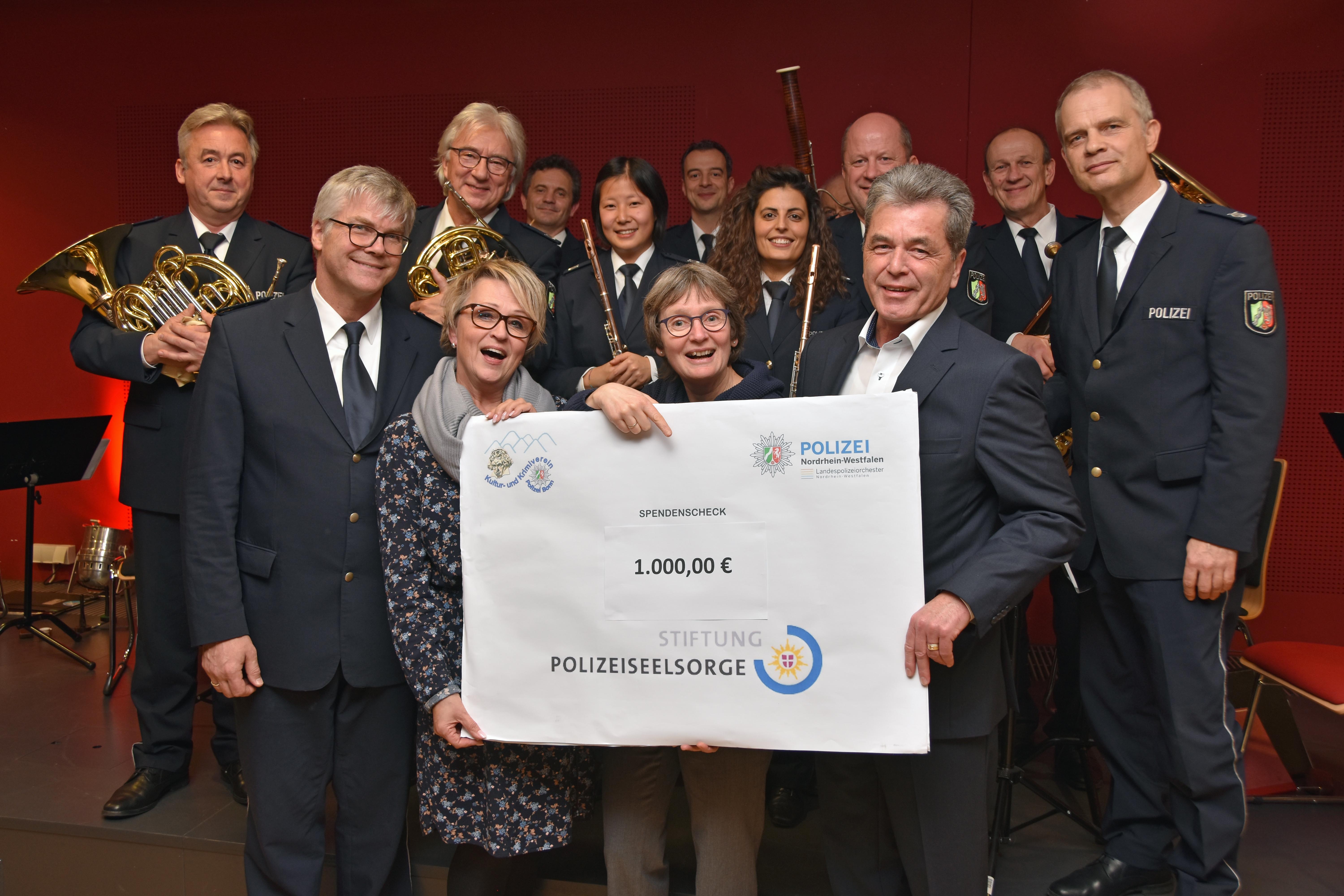 Bonns Leitender Polizeidirektor Helmut Pfau (re) und Christa Wennmann vom Kulturverein übergeben einen Spendenscheck an Polizeipfarrerin Claudia Heinemann